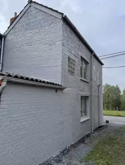 Pignon et façade d’une maison repeints en gris clair
